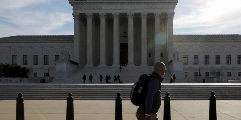 A pedestrian walks by the U.S. Supreme Court building in Washington, U.S. March 15, 2022.